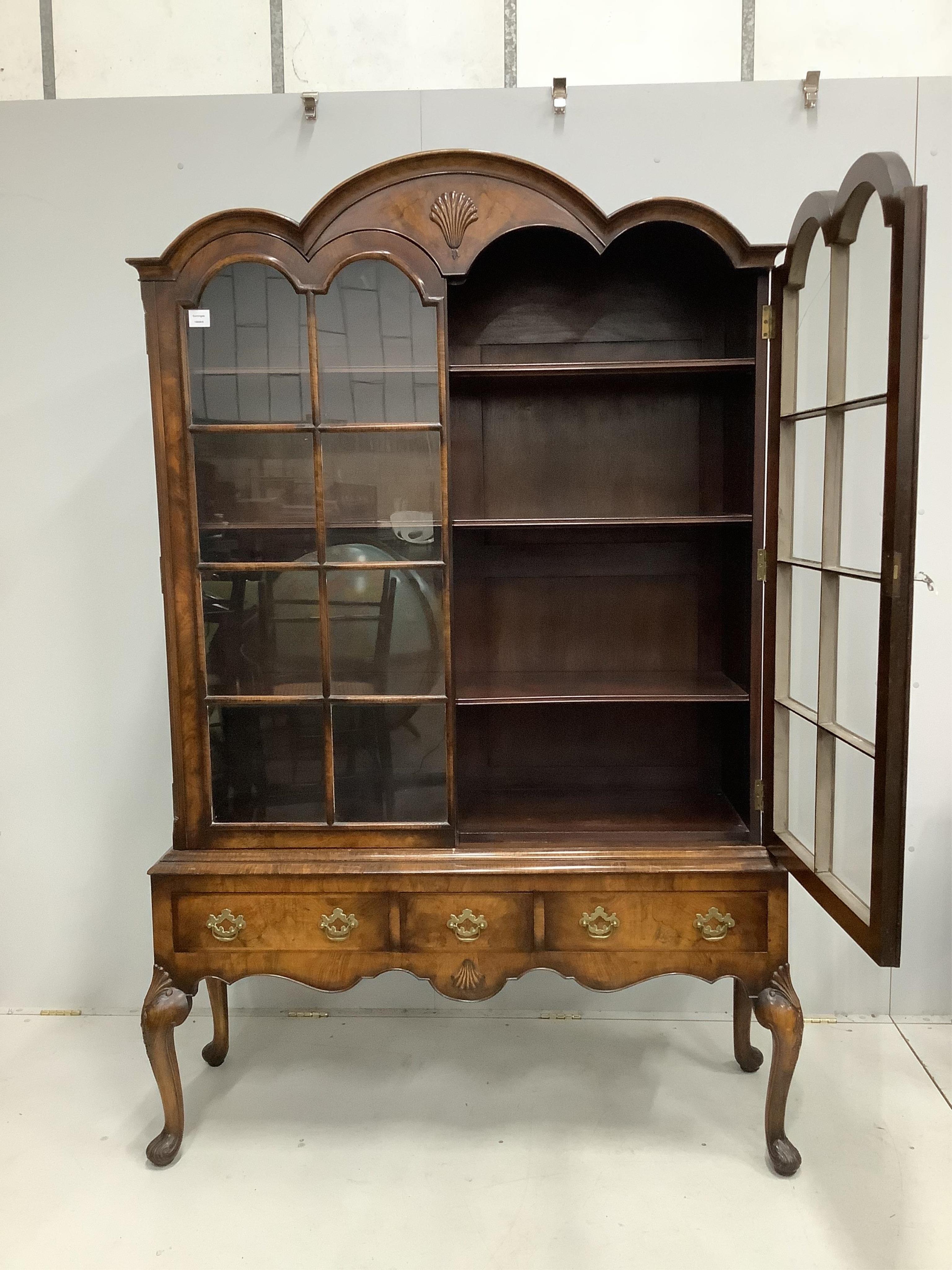 A 1930's Queen Anne Revival figured walnut bookcase, width 136cm, height 205cm. Condition - good